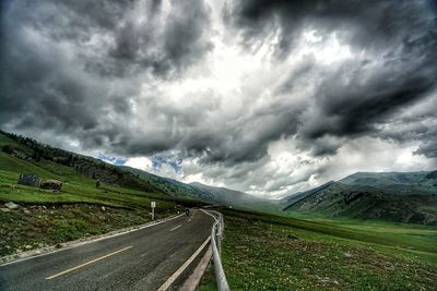 Scenic view of highway against storm clouds