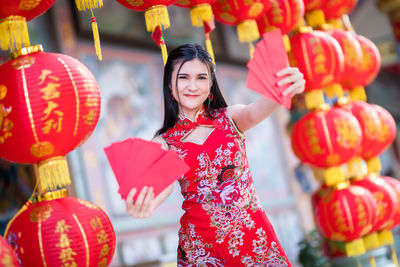 Portrait of smiling woman with red lanterns