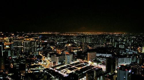 Aerial view of illuminated buildings against sky in city at night