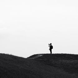 Man standing on field against clear sky