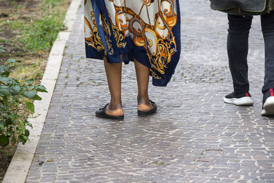 Low section of women standing on footpath