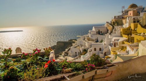 Scenic view of sea by buildings against sky