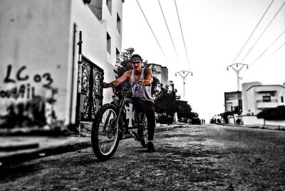 Man riding bicycle on street in city