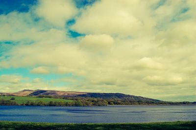 Scenic view of lake against cloudy sky