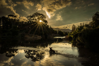 Scenic view of river against sky at sunset