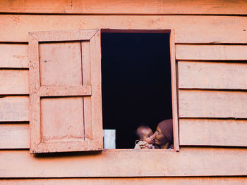 FULL LENGTH OF MAN LYING ON WALL BY WINDOW