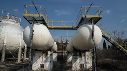 Storage tank at industry against sky