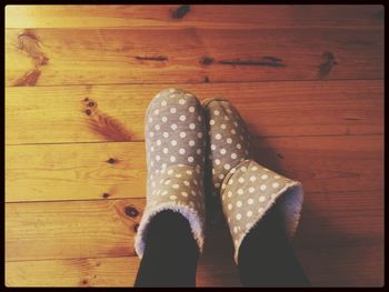 Rear view of woman standing on wooden floor