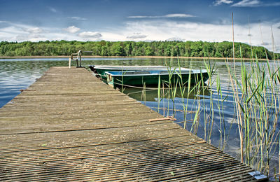 Wooden pier on water against sky