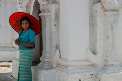 Portrait of woman standing against building