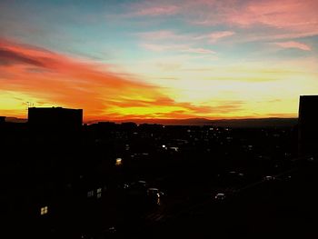 Silhouette cityscape against sky during sunset