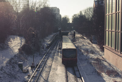 Railroad tracks by trees against sky during winter