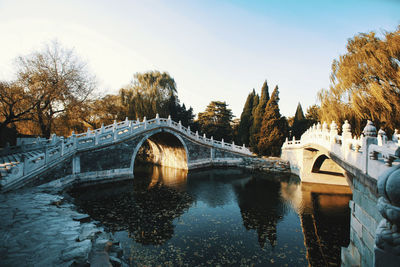 Arch bridge over river against sky