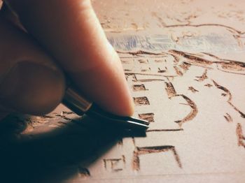 Close-up of hand carving with tool on wood