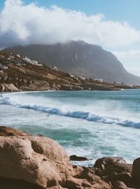 Scenic view of sea and mountains against sky