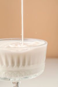 Milk pours into a beautiful crystal glass and splashes around.