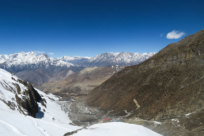 Scenic view of snowcapped mountains against blue sky