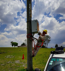 Low angle view of traditional windmill on field against sky