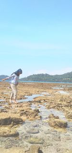 Man standing on shore against sky