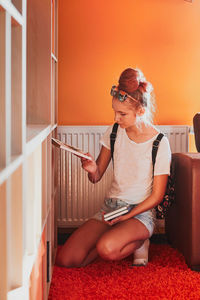 Young woman sitting on sofa at home