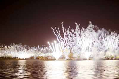 Panoramic view of illuminated fireworks against sky at night