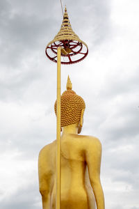 Low angle view of statue against temple against sky