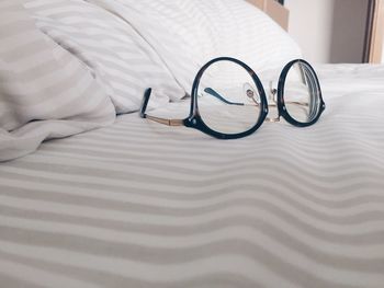 Close-up of eyeglasses on bed