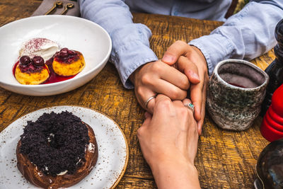 High angle view of hand holding ice cream on table