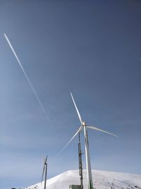 Low angle view of windmill against blue sky