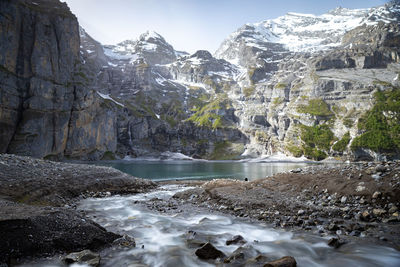 Scenic view of waterfall against rocky mountains