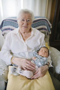 Portrait of great grandmother with her great granddaughter at home
