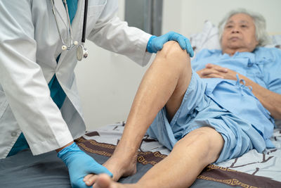 Midsection of doctor examining patient in hospital
