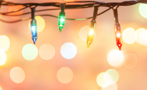 Close-up of illuminated lighting equipment hanging on christmas lights
