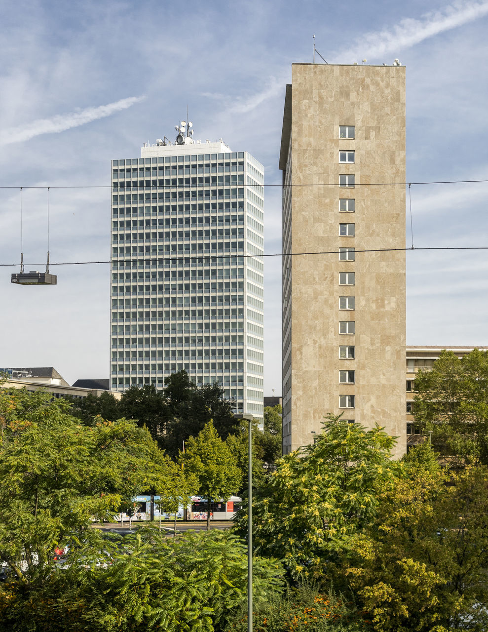 built structure, architecture, building exterior, plant, tree, building, sky, cloud - sky, city, nature, no people, day, tower, outdoors, office building exterior, transportation, mode of transportation, tall - high, low angle view, street, skyscraper