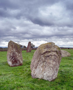 Rocks on field against sky