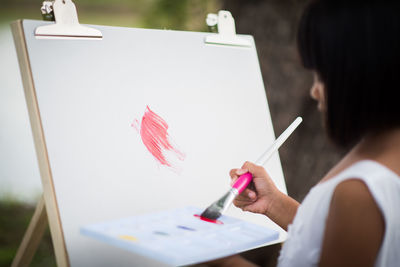 Close-up of girl painting on canvas