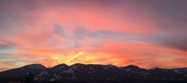 Scenic view of silhouette mountains against dramatic sky