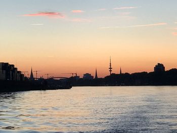 View of city at waterfront during sunset