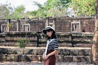 Full length of woman standing against wall