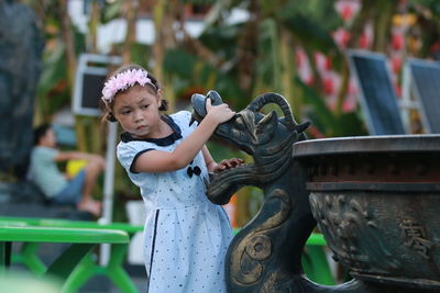 Portrait of young woman standing in park
