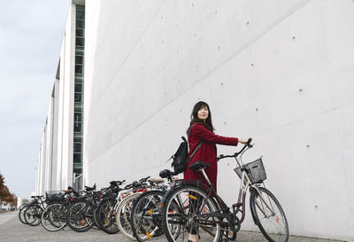 Businesswoman taking bicycle in the background of modern building