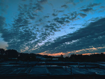 Silhouette trees on field against sky at sunset