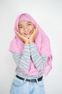 Portrait of a smiling teenage girl against white background