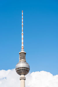 Television tower against blue sky with clouds