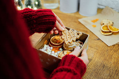 Christmas homemade sweet hampers in female hands. woman hsnds holding christmas sweet gift box