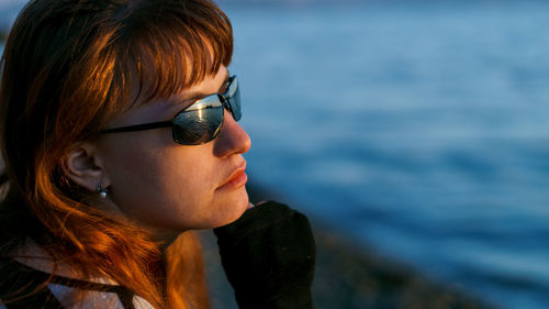 Close-up of woman in sunglasses by sea