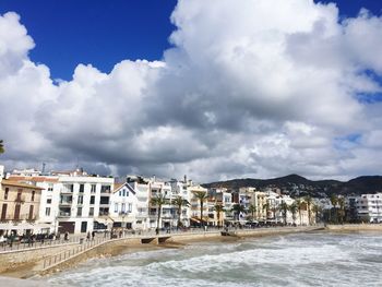 Buildings in town against cloudy sky