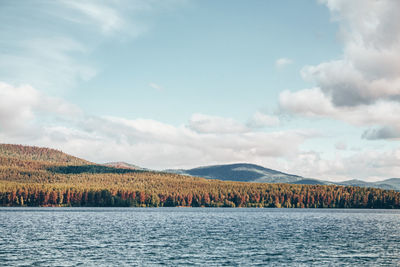 Scenic view of lake by mountain against sky