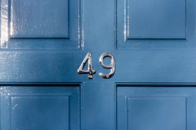 House number 49 on a blue wooden front door in london 