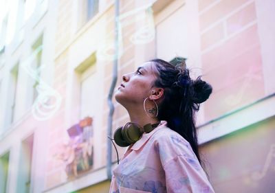 Side view of girl standing against wall